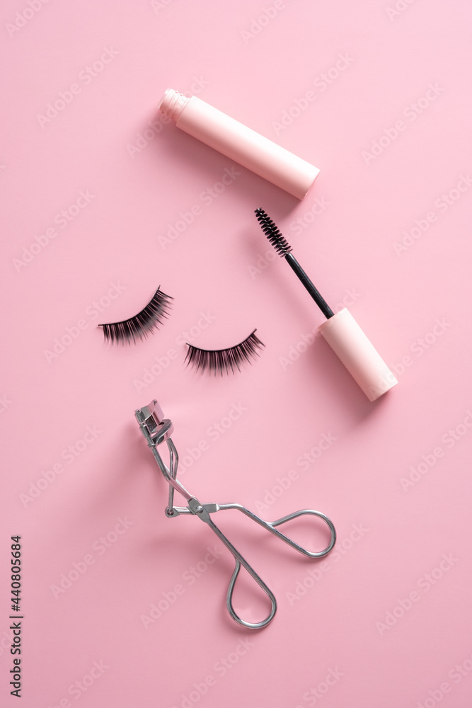 Makeup professional cosmetics on pink background top view. Flat lay mascara,  false eyelashes, curler. Photos | Adobe Stock