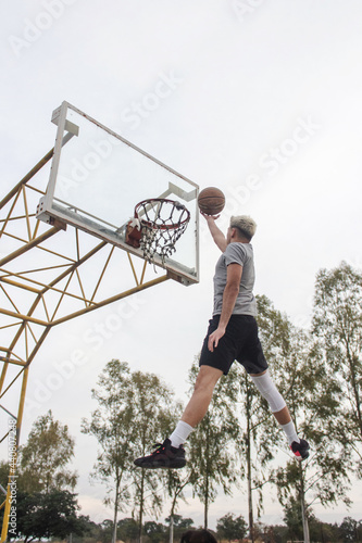 Counter shot of a young man making a leap for a basket.