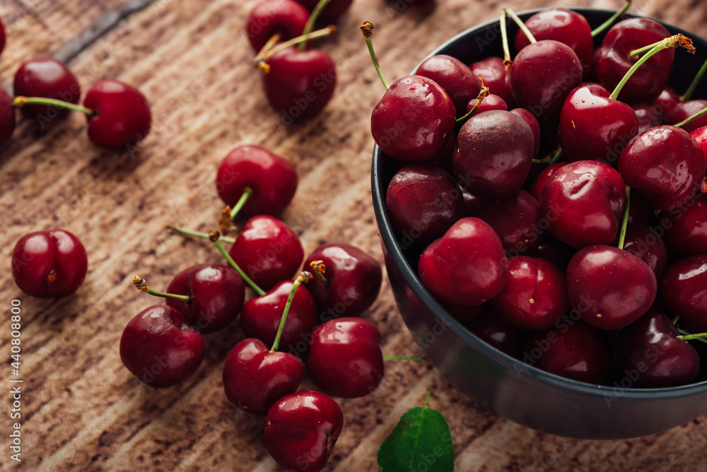 Closeup shot of fresh red cherries on a bowl on a wooden table Closeup shot of fresh red cherries on a bowl on a wooden table