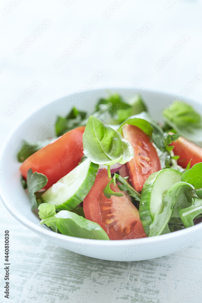 Simple Salad with Tomatoes, Cucumber and fresh Basil. Bright wooden background. Close up. Copy space. Simple Salad with Tomatoes, Cucumber and fresh Basil. Bright wooden background. Close up. Copy space.