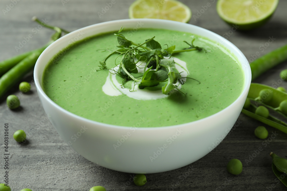 Concept of tasty eating with pea soup on gray textured table Concept of tasty eating with pea soup on gray textured table