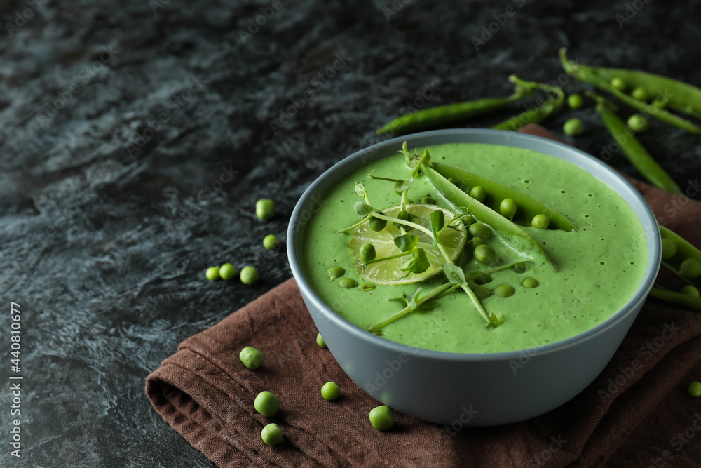 Concept of tasty eating with pea soup on black smokey table Concept of tasty eating with pea soup on black smokey table
