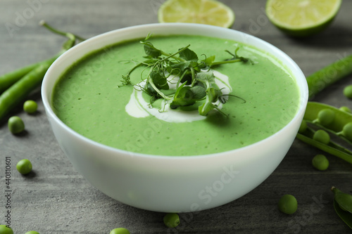 Concept of tasty eating with pea soup on gray textured table