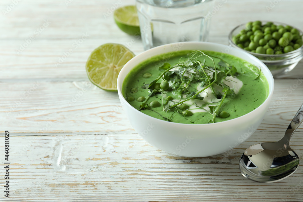 Concept of tasty eating with pea soup on white wooden table Concept of tasty eating with pea soup on white wooden table