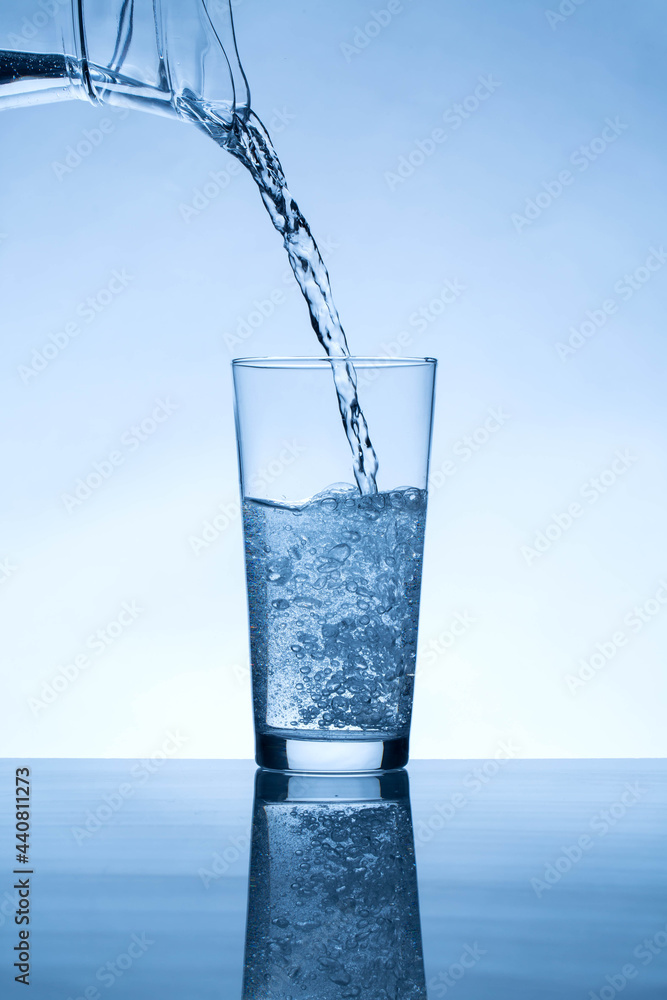 water from jug pouring into glass water from jug pouring into glass
