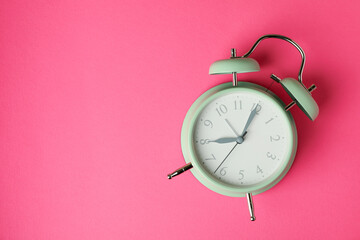 Stylish mint alarm clock on pink background