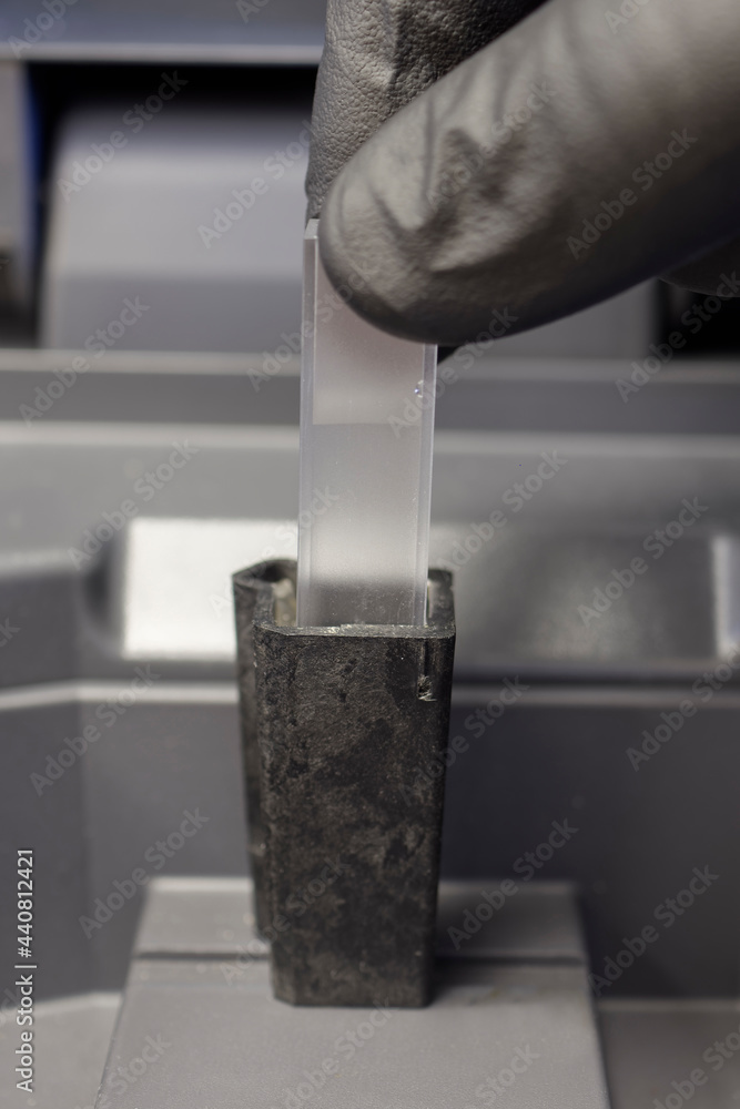 Cuvette containing a sample being placed into a spectrophotometer. foto
