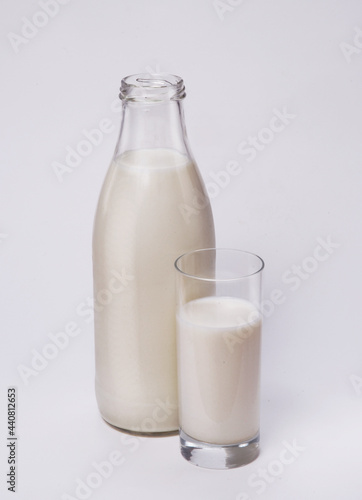 Bottle and glass of fresh milk on white background.