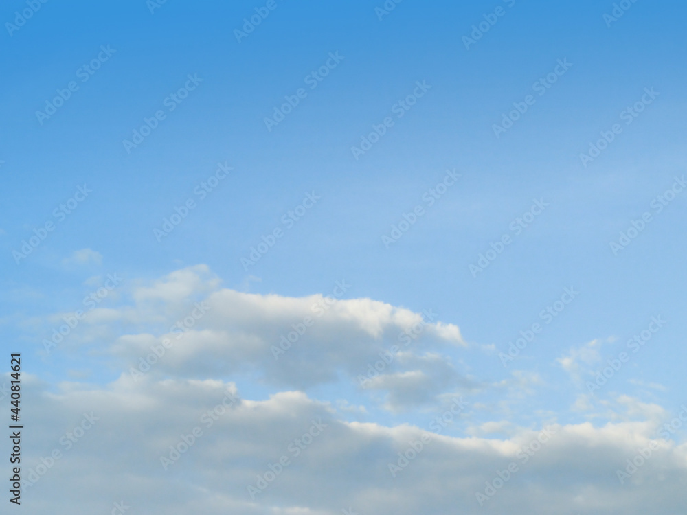 White fluffy clouds in the blue sky background. The image in clearing day and good weather on morning of the summer season.