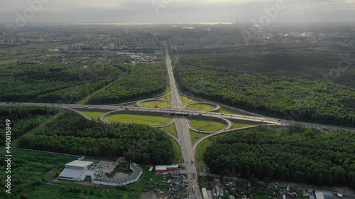AERIAL. Traffic interchange. Top view of the road, city and forest. Summer video from the drone. © skymediapro