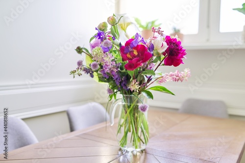 Bouquet of bright flowers on the table in jug