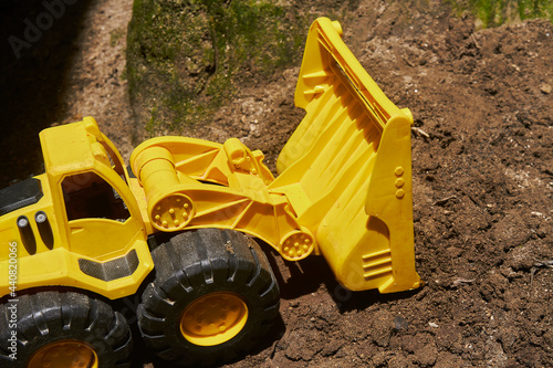 unbranded toy bulldozer, Unmarked toy bulldozer digging along a dirt wall