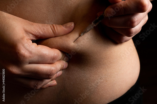 Injection of insulin into abdomen, stomach of pregnant women from syringe, diabetes