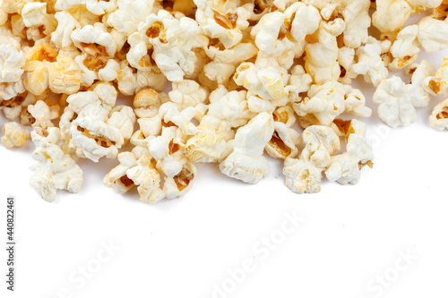 Heap of delicious popcorn, isolated on white background. Scattered popcorn texture background. Close-up.