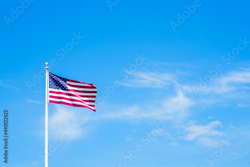 Canvas Print Amaerican flag on pole with blue sky