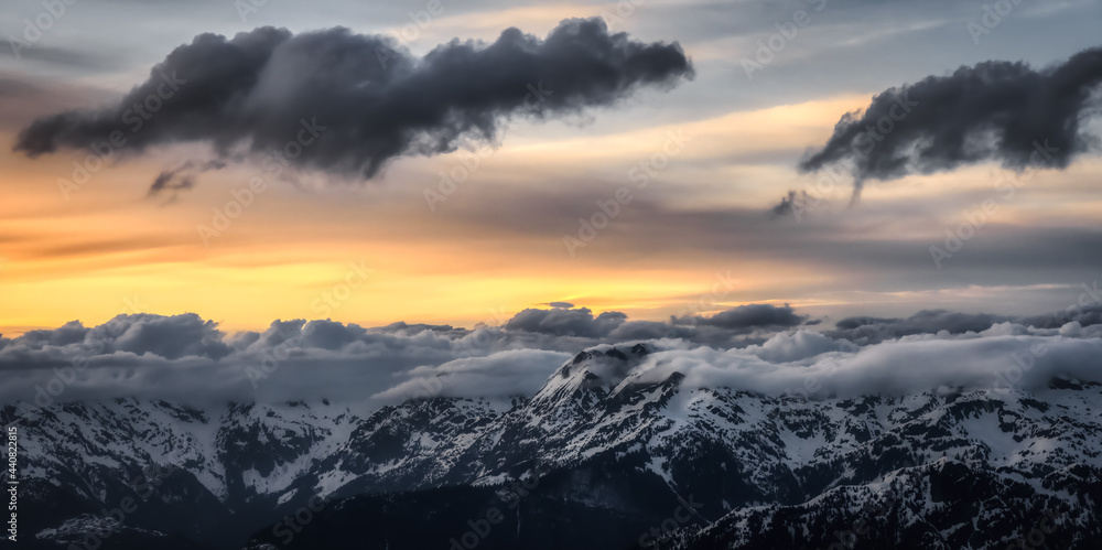 Aerial View from Airplane of Canadian Mountain Landscape in Spring time. Colorful Sunset Sky. North of Vancouver, British Columbia, Canada. Dark Mood Art Render