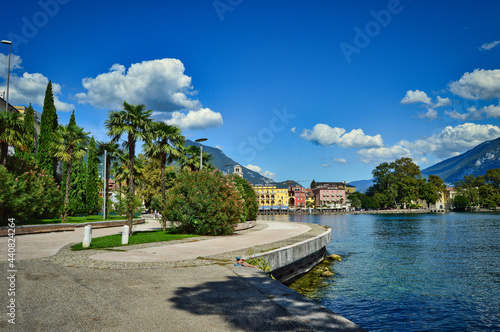 Fototapeta Naklejka Na Ścianę i Meble -  Riva del Garda, Italy- garda lake with pro, bmenade, palms, peaks, town, beach, shore, blue sky