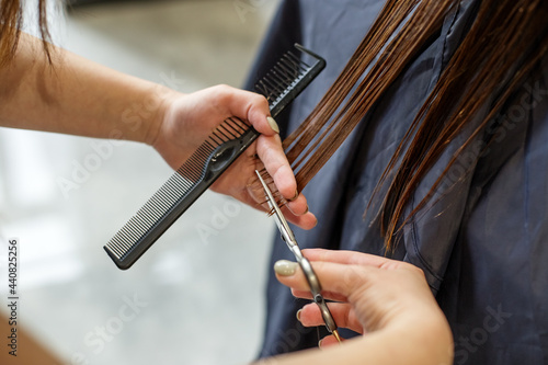 barber cuts the hair of a girl with long hair, trimming split ends of hair, hairdressing