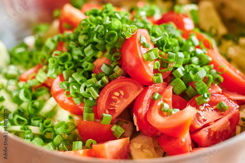 Macro photo of fresh red tomatoes and green onions salad. Food background