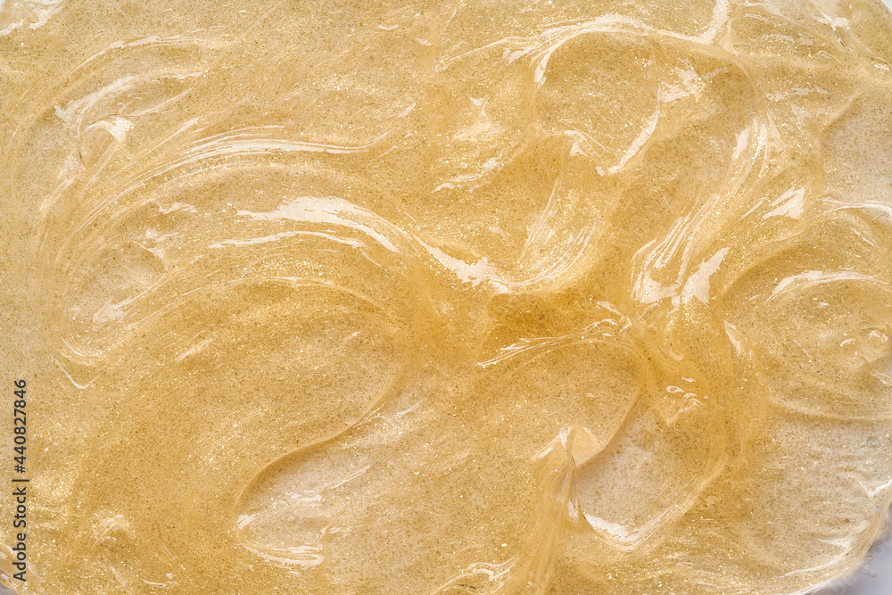 Transparent smear and texture of golden cosmetic gel on a white background. Transparent smear and texture of golden cosmetic gel on a white background.