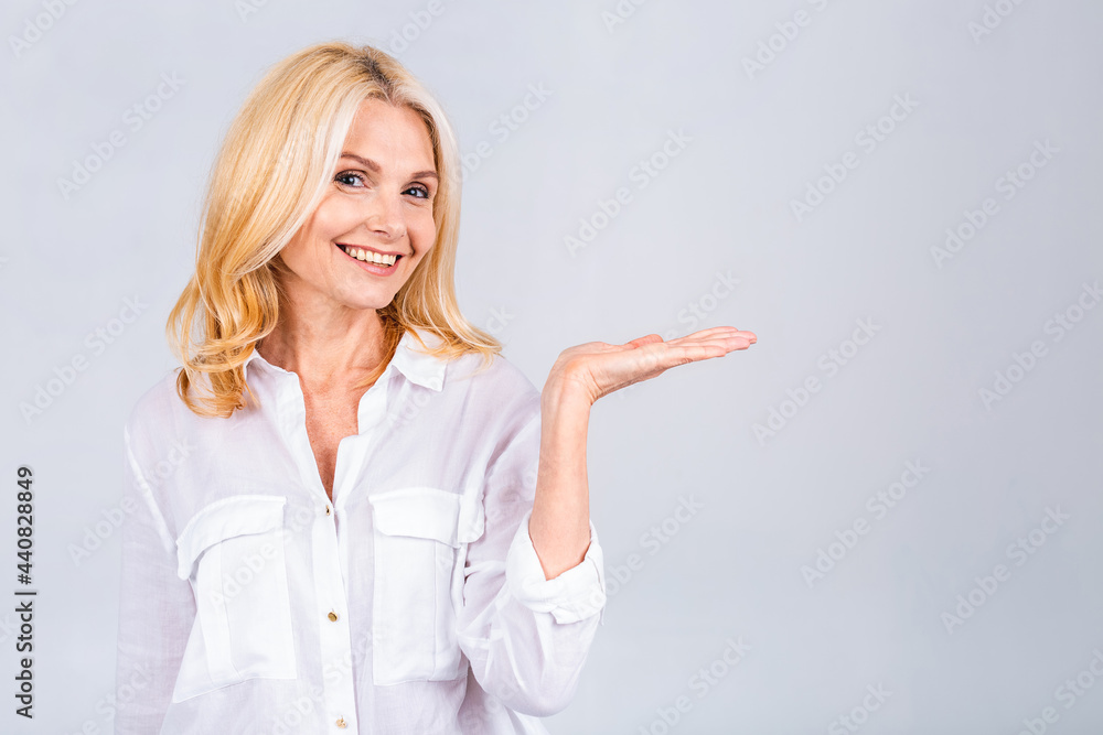 Portrait of attractive cheerful woman demonstrating copy space ad new novelty offer isolated over grey or white color background, pointing finger away. Portrait of attractive cheerful woman demonstrating copy space ad new novelty offer isolated over grey or white color background, pointing finger away.