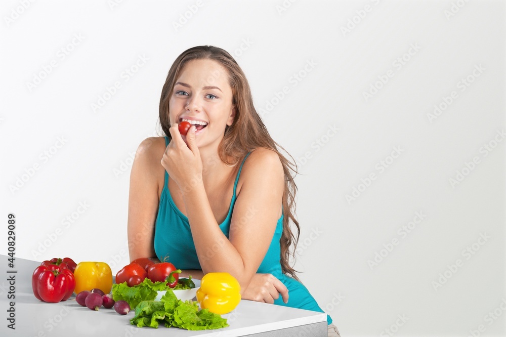Portrait of a happy pretty young woman eating fresh vegetables. Portrait of a happy pretty young woman eating fresh vegetables.