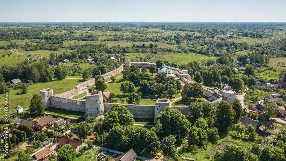 Aerial view of Izborsk fortress in Russia. Semi-ruined walls, towers and courtyards around a 14th-century fortress