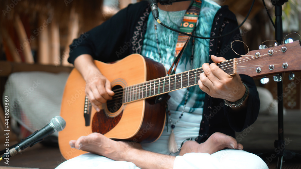 Obraz premium The young man plays hands and on a classic acoustic wooden guitar on the street