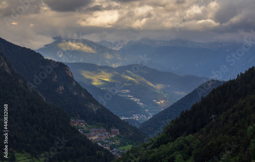 view from the forest of a village among the mountains and under a cloudy sky