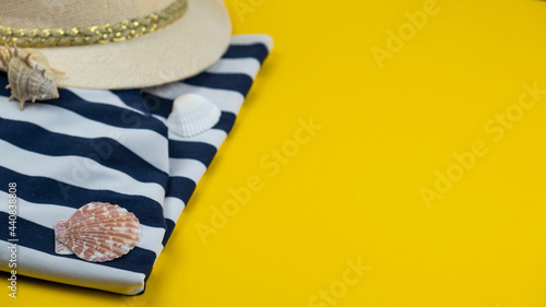 Summer background with beaach tunic, hat and seashells. Copy space