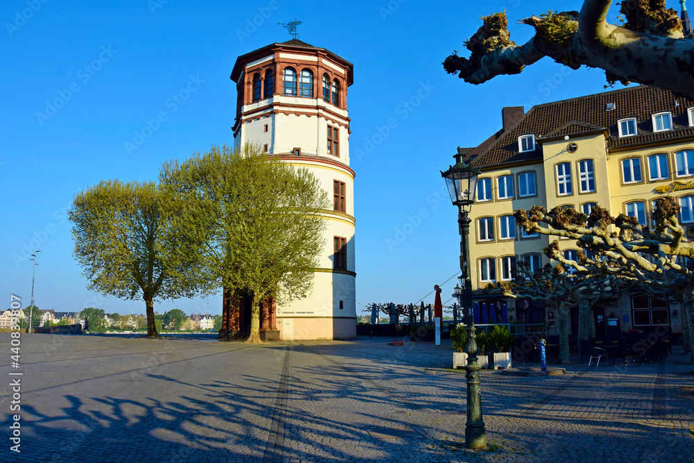 Naklejka premium City embankment with an old tower in the sun