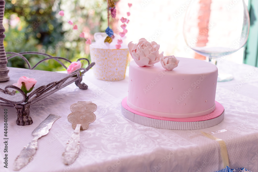 Mesa de cumpleaños con torta, cubiertos y adornos en tonos rosa pastel Mesa de cumpleaños con torta, cubiertos y adornos en tonos rosa pastel