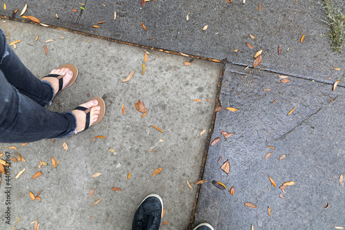 3 human feet standing on the sidewalk with room for copy space
