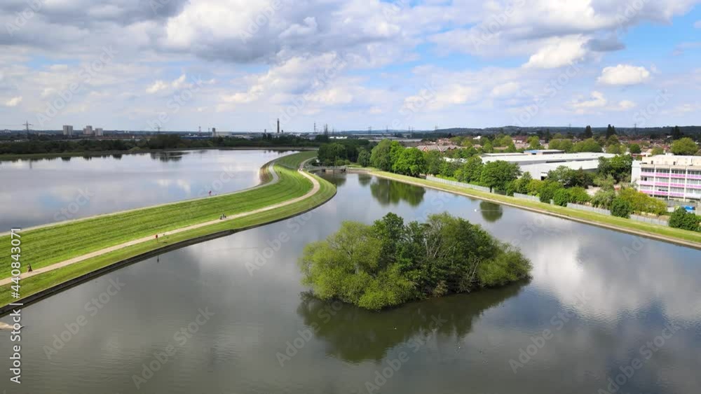 Aerial drone view on calm water surface in reservoir. Trees of island in middle. Sunny day in urban nature Aerial drone view on calm water surface in reservoir. Trees of island in middle. Sunny day in urban nature