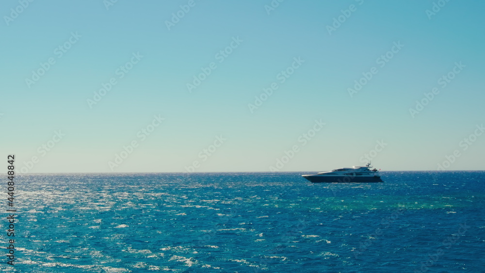 Luxury Yacht Sailing in Turquoise Mediterranean Sea in Sunny Summer Day with Clear Blue Sky. Rich Life and and Marine Vacation Tourism on Private Boat in Greece. 4K Wide Handheld Shot