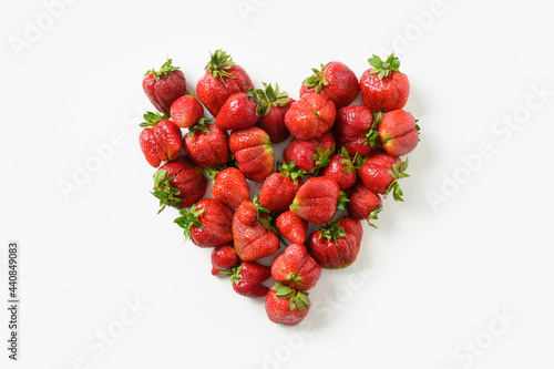 Delicious ugly ripe organic strawberry in shape of heart isolated on white background. View from above. Concept organic eco products.