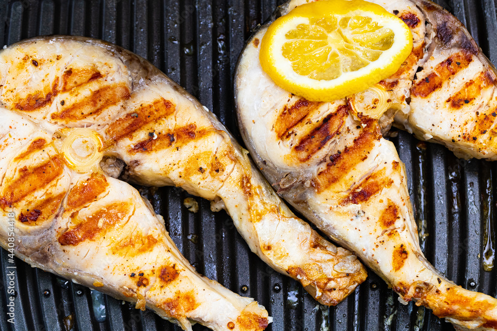 Grilled fish in grill pan with lemon Grilled fish in grill pan with lemon