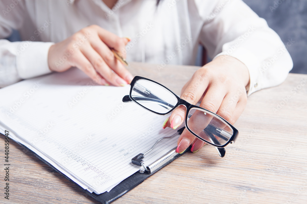 woman checks papers in front of the table. optical glasses woman checks papers in front of the table. optical glasses