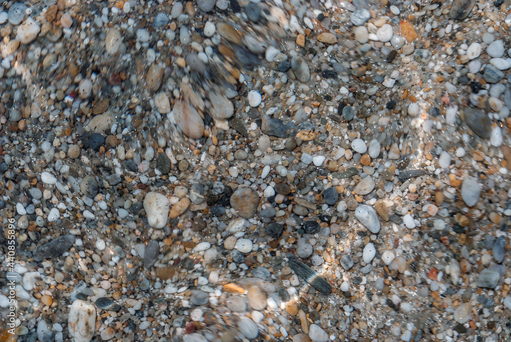Waves Making Lens Effect over Colourful Stones Bottom Texture on Beach of Singitic Gulf in Aegean Sea - Background on Sithonia Chalkidiki Greece Waves Making Lens Effect over Colourful Stones Bottom Texture on Beach of Singitic Gulf in Aegean Sea - Background on Sithonia Chalkidiki Greece
