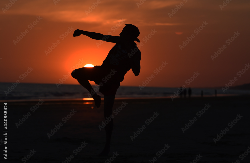 a fighter training on the beach at sunset
