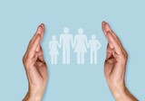 Hands holding family figure on a background. Insurance concept