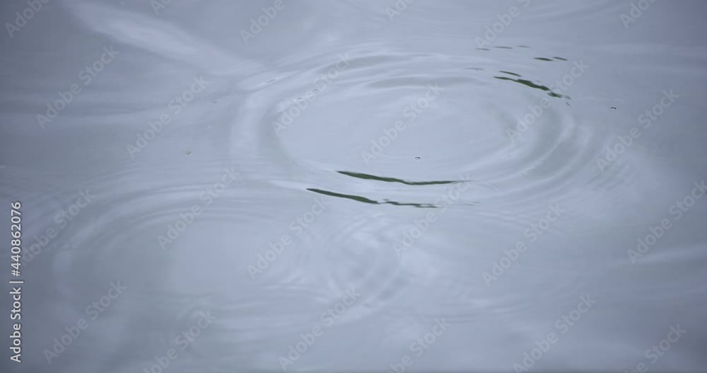 A slow motion of rain drop in the water the pond rainy day closeup A slow motion of rain drop in the water the pond rainy day closeup