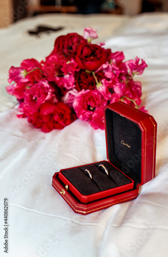 21 June 2021. Two gold wedding rings Cartier on the background of a wedding bouquet, in a red box. Holiday. Pink flowers. High quality photo. Editorial photo.