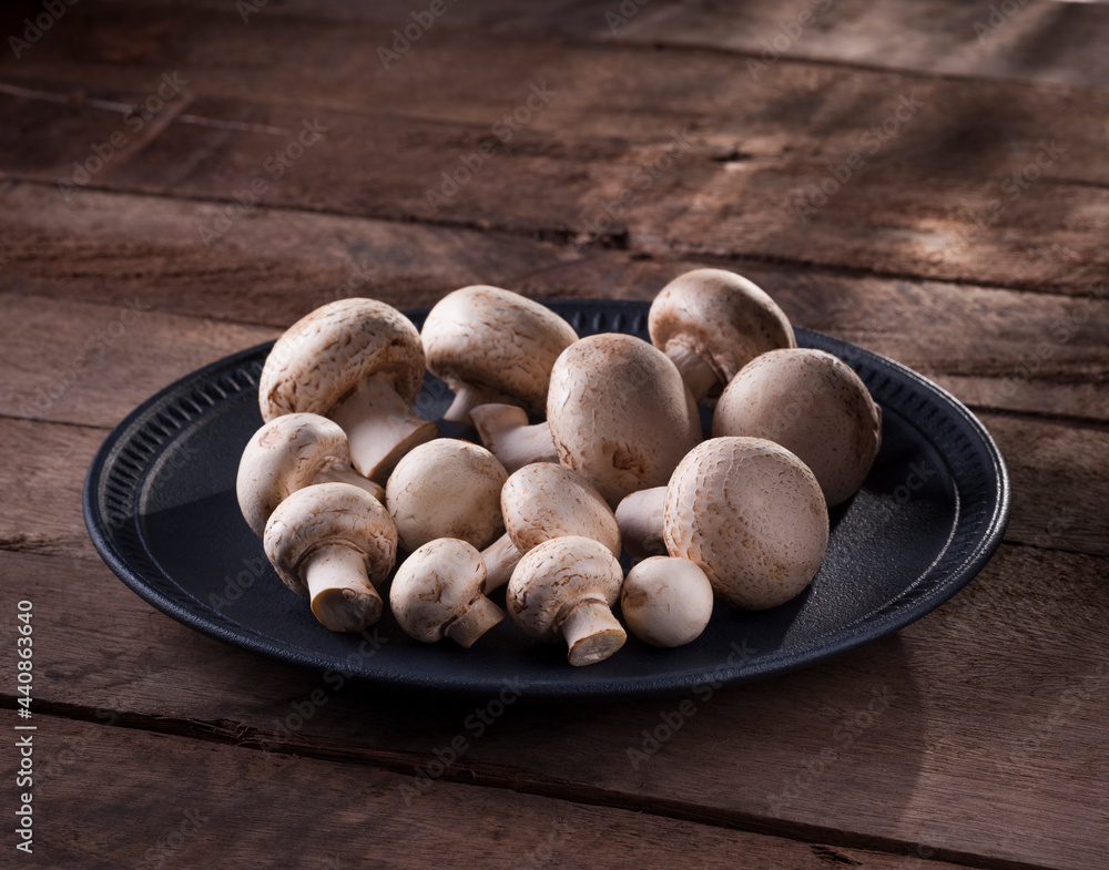 some paris mushrooms in plate on a rustic wooden table some paris mushrooms in plate on a rustic wooden table