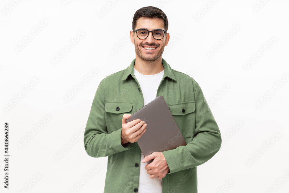 © Damir Khabirov - Young smiling modern male teacher holding laptop, isolated on gray background
