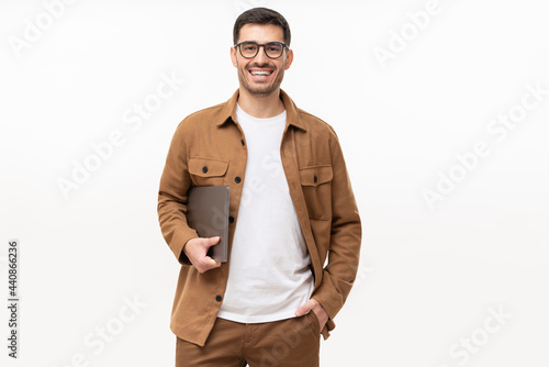 Young smiling modern man or male teacher holding laptop, isolated on gray background photo
