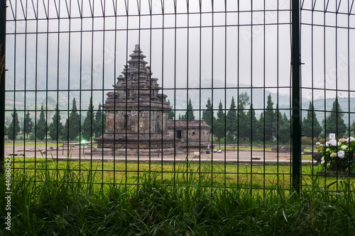 Arjuna and Semar temples behind a black metal gate photo