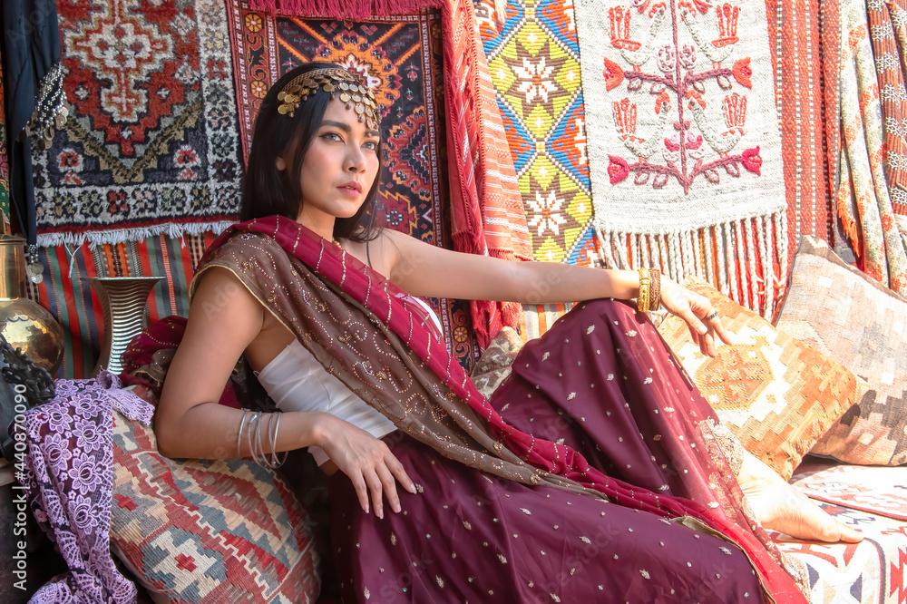 Fototapeta premium Asian woman attractive model dressed in posh, gildet, indian costume