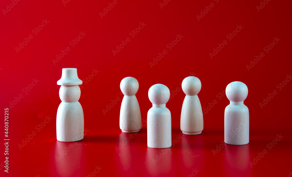 the wooden figure of a man wearing hat stands out from the crowd. the wooden figure of a man wearing hat stands out from the crowd.