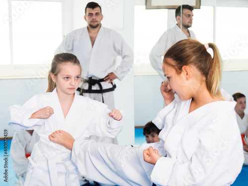 Young girls practicing in pair to use karate technique during class